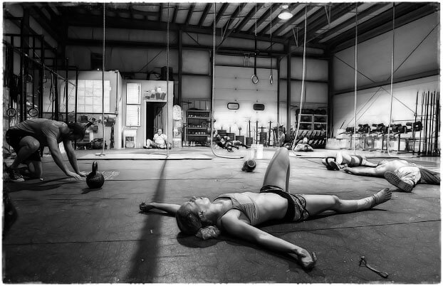 Девушка лежит на полу в спортзале усталость
